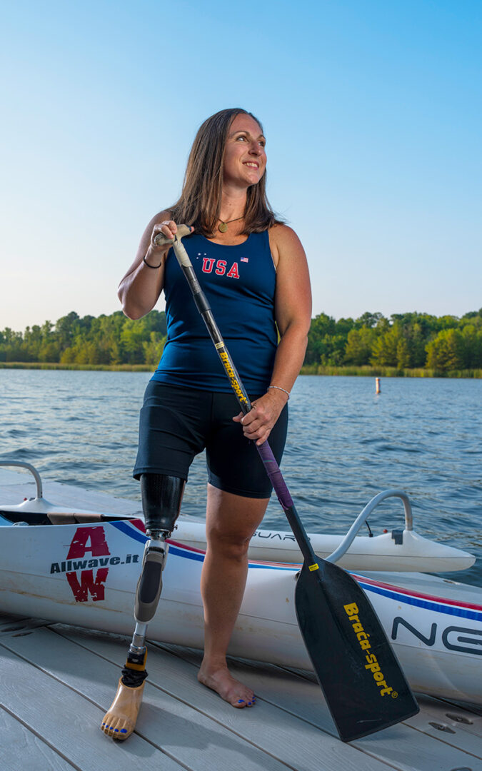 Jillian standing tall with paddle and canoe in background.