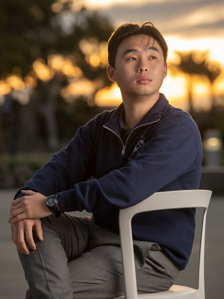 Derrick Nguyen seated in chair at sunset.