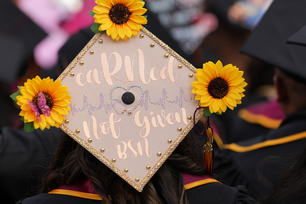 Graduation cap decorated with flowers and text: eaRNed, not given. The degree is a Bachelor of Science in Nursing.