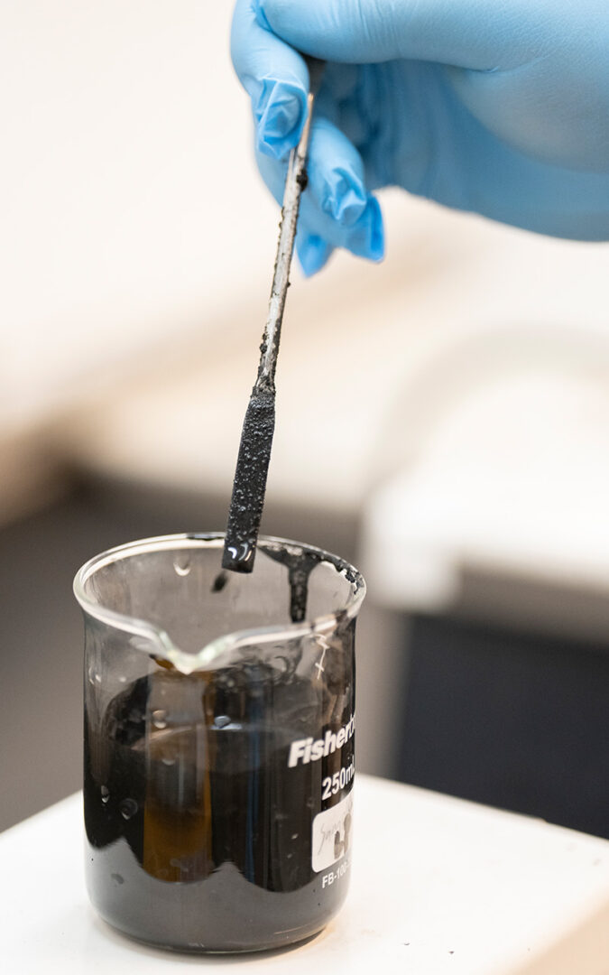 Instrument being dipped into beaker of biochar