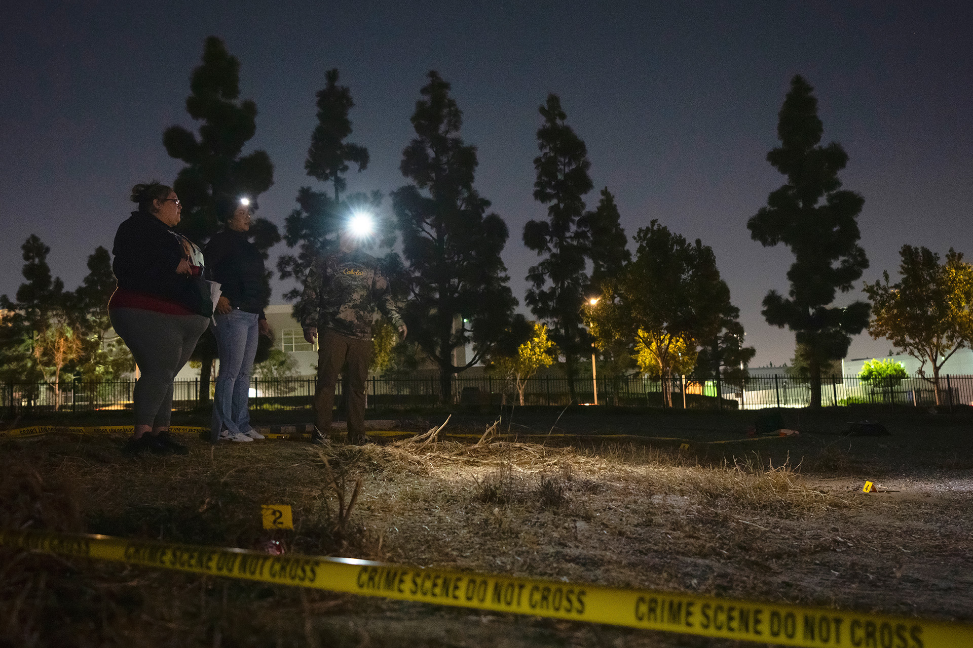 Students at mock crime scene in field at night.