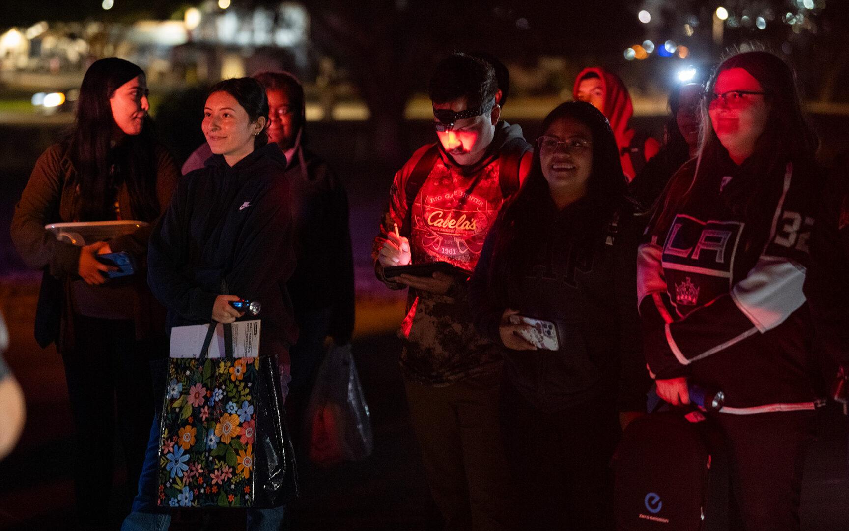 Students gathered outside at night for class.