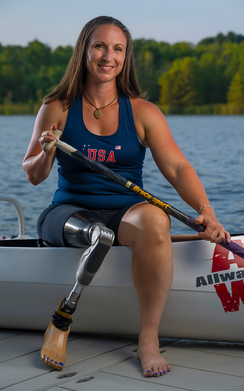 JIllian seated on edge of canoe on pier.
