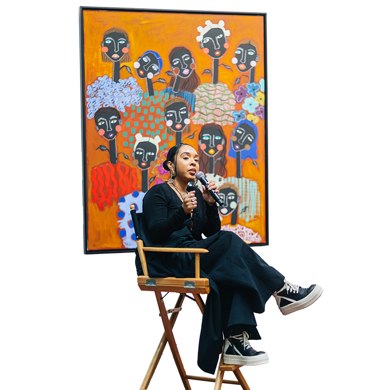 Artist Cristina Martinez seated in chair speaking on microphone
